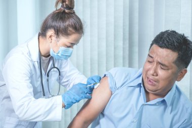 Doktorun elinde şırınga vardı ve virüsün yayılmasını önlemek için klinikteki bir hastayı aşılamak üzereydi..