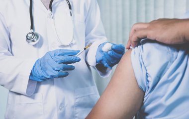 Doktorun elinde şırınga vardı ve virüsün yayılmasını önlemek için klinikteki bir hastayı aşılamak üzereydi..