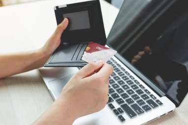 İş kadınları, bir sonraki tatil, ödeme e-ticaret, internet bankacılığı, harcama paraları için evden bir dizüstü bilgisayarla kredi kartlarını cebinden online alışverişe çıkarıyorlar..