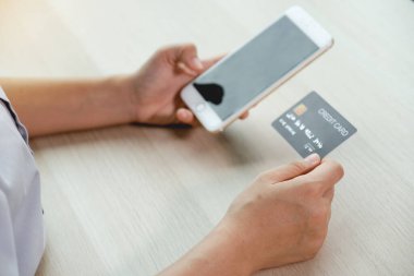 İş adamının elinde evden gelen akıllı telefondan online alışveriş için kredi kartı var. Ödeme e-ticaret, internet bankacılığı, gelecek tatiller için para harcamak..