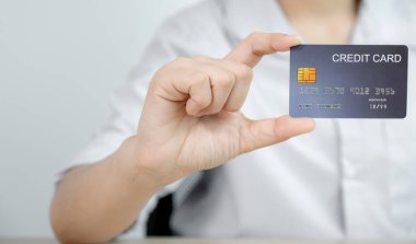 İş adamı elinde evden online alışveriş için kredi kartı tutuyor, ödeme e-ticaret, internet bankacılığı, gelecek tatiller için para harcıyor..