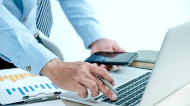 İşadamı, iş hedefleri belirlemek ve yeni arsaya ulaşmayı planlamak için ofisteki bilgisayarı kullanarak grafiği analiz ediyor.