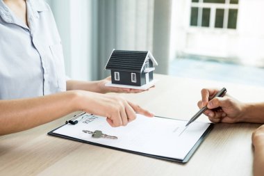 Emlakçılar iş sözleşmesi, kira, satın alma, ipotek, kredi veya ev sigortası anlaşmasını açıkladıktan sonra ev modeli iş kadını el ve alıcı el imzaları sözleşmesi imzaladı.