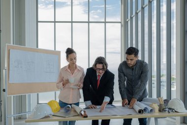 Mühendisler inşaat çizimlerini incelemek, plan yapmak ve inşaata başlamadan önce işleri dağıtmak için toplanıyorlar..