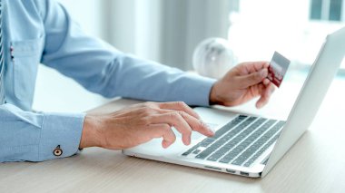İş kadını el bilgisayarı kullanıyor ve evden online alışveriş için kredi kartı tutuyor, ödeme e-ticaret, internet bankacılığı, gelecek tatiller için para harcıyor..