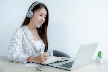 Genç kız öğrenci dizüstü bilgisayar dersi izlerken not alıyor online sınıf video konferansı eğitimi evden yeniden öğreniyor.