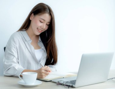 Genç kız öğrenci dizüstü bilgisayar dersi izlerken not alıyor online sınıf video konferansı eğitimi evden yeniden öğreniyor.