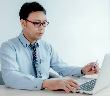 İş adamı kredi kartını bilgisayarla, ödeme e-ticaretiyle, internet bankacılığıyla, gelecek tatiller için para harcamakla evden online alışverişe çıkarıyor..