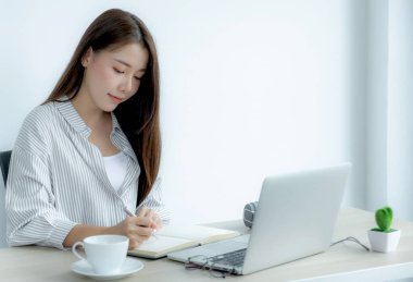 Genç kız öğrenci dizüstü bilgisayar dersi izlerken not alıyor online sınıf video konferansı eğitimi evden yeniden öğreniyor.