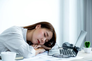 Mutsuz Asyalı iş kadını çalışanı ofis bilgisayarında ve çizelgesinde sıkılmış. Ofis sendromu konsepti..