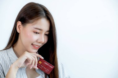 Kırmızı kredi kartı tutan uzun saçlı, güzel bir Asyalı kadının portresi. Gözleri kamerada pırıl pırıl parlıyordu. İndirimli ürünlere göre alışverişe hazır..