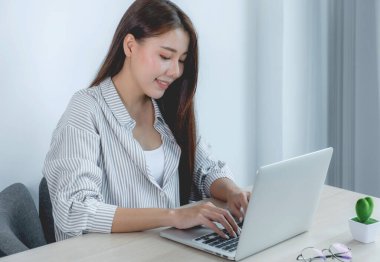 İş kadını, iş hedeflerini zorlamak ve yeni bir hedefe ulaşmak için bilgisayarını ve bilgisayarını bilgisayarla analiz ediyor..