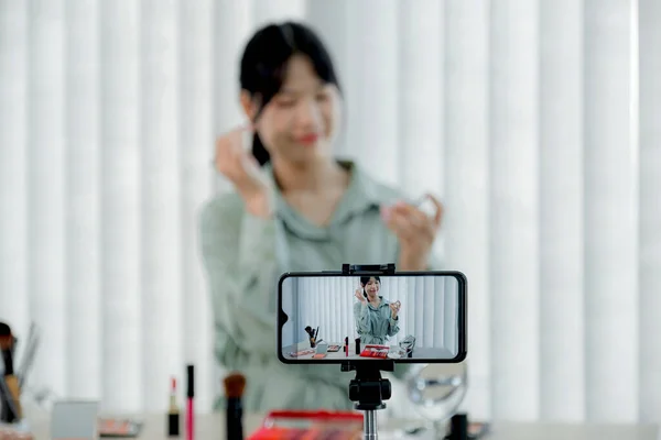 Smartphone recording Beautiful Asia female vlogger who showing cosmetics makeup products and giving recommended for her beauty blog with digital smartphone