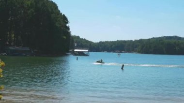 Gölde dönen bir çift jet ski ve iki yaz aylarında güneşli bir günde suda olduktan sonra rıhtıma geri dönmeye karar