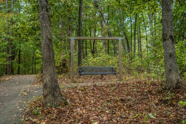 Swingende parkbank in het bos — Stockfoto