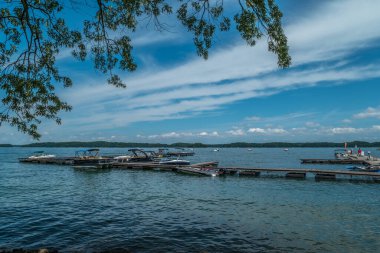 Yazın güneşli ve güneşli bir günde gölde bol bol su sporu yapan tekneler rıhtımlara demirlemişti.