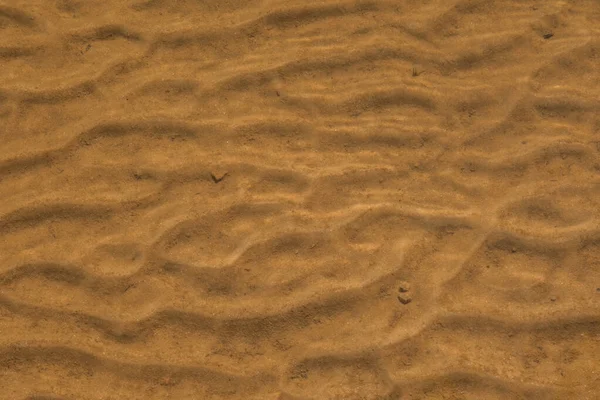 晴れた日に湖の穏やかな流れの波紋から砂のパターンで透明な水を見下ろす — ストック写真