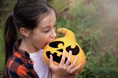 Kız balkabağını Jacks suratıyla ısırıyor.