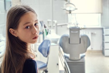 Genç bir kız dönüp dişçi muayenehanesine girmek istemiyor.