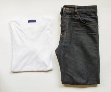 Beyaz ahşap arka plan üzerinde kot pantolon ile T-shirt.