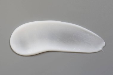 Gri arka planda izole kozmetik krem losyon.