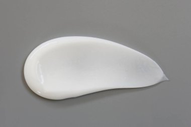 Gri arka planda izole kozmetik krem losyon.