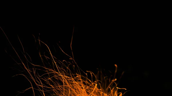 Chamas de fogo com faíscas em um fundo preto — Fotografia de Stock