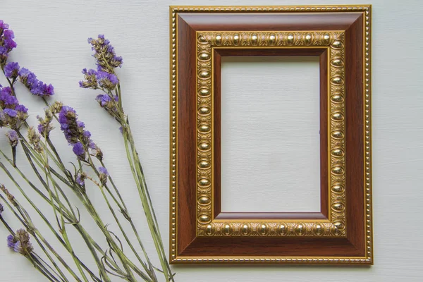 Statice fialová květinka na dřevěné podlaze. S rámečkem. — Stock fotografie