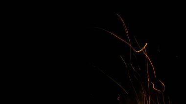 Siyah arkaplanda kıvılcımlar saçan ateş alevleri