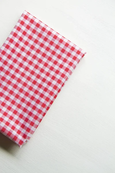 Red towel over wooden kitchen table. View from above with copy s — Stock Photo, Image