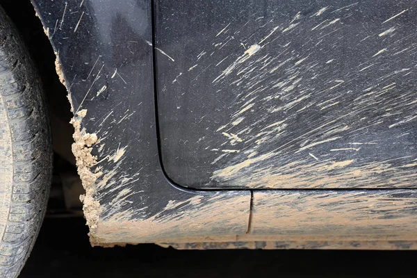 A talajtörmelékek fröccsenése rá egy piszkos autót egy esős napon. — Stock Fotó