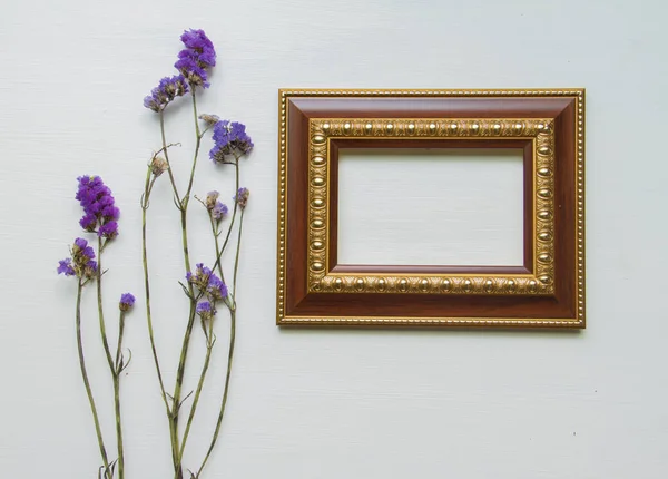 Statice fialová květinka na dřevěné podlaze. S rámečkem. — Stock fotografie