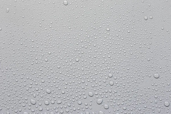 Gotas de agua sobre un fondo gris — Foto de Stock