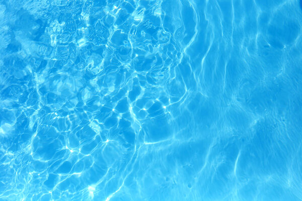 Blue color water in swimming pool rippled water detail backgroun