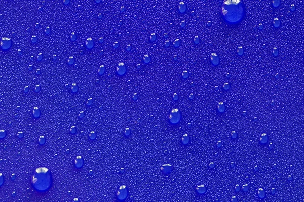 Kapky vody na modrém pozadí. — Stock fotografie