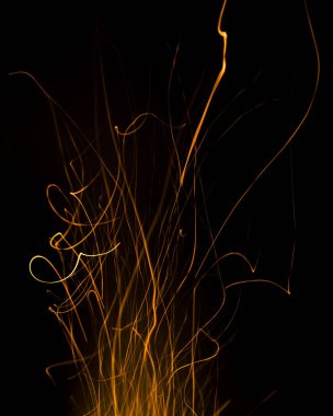 Siyah arkaplanda kıvılcımlar saçan ateş alevleri