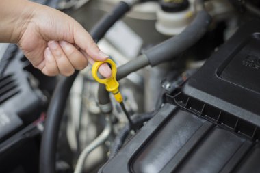 Kadının eli kaputu açalı motoru kontrol ediyor..