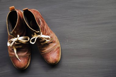 Bir ahşap zemin üzerinde kahverengi deri ayakkabı.