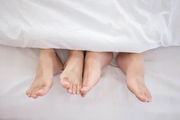 Close up of two men\'s feet on the bed LGBT concept.