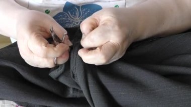 Kadın terzi elbiseleri tamir eder.