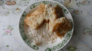 Tabakta pilavlı kızarmış morina balığı.