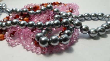 Beyaz bir arka planda mücevher takıyor. 