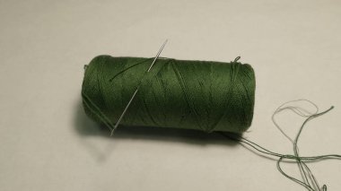 Beyaz arkaplanda yeşil bir iplik yumağı