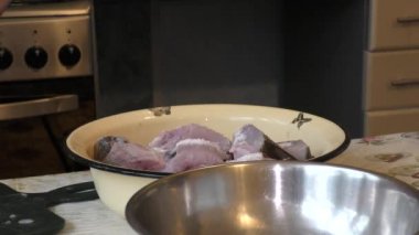 Aşçı çiğ balığı bıçakla temizler.