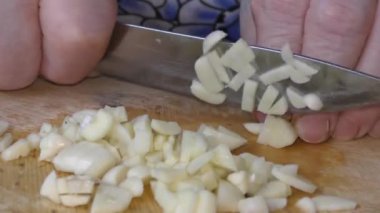 Aşçı bıçakla sarımsak öğütür.