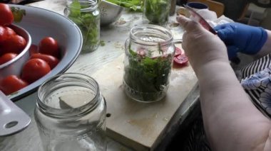 Bir kadın konserve domates hazırlar.