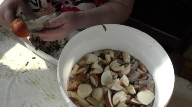 Bir kadın mantarları bıçakla temizler.