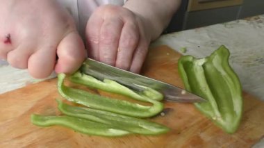 Bir kadın biberi bıçakla keser.