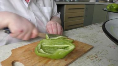 Bir kadın biberi bıçakla keser.
