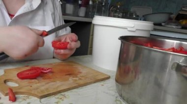 Bir kadın bıçakla domates kesiyor.